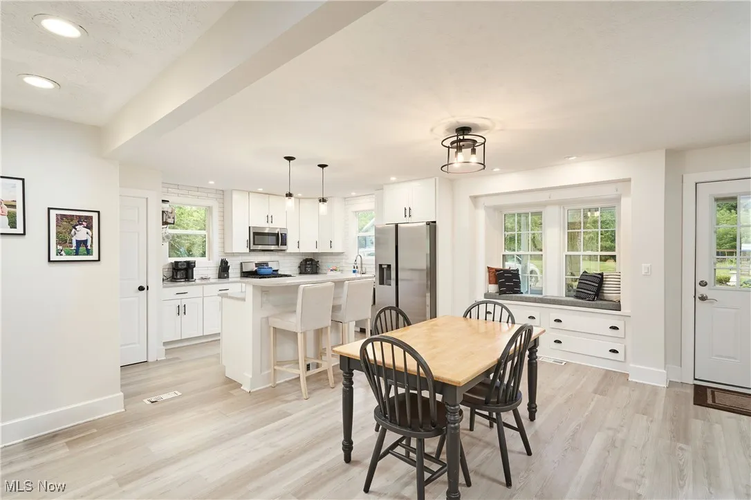 Dining space with light wood-type flooring and recessed lighting