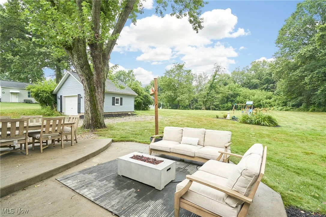 View of patio featuring an outdoor living space with a fire pit and a playground