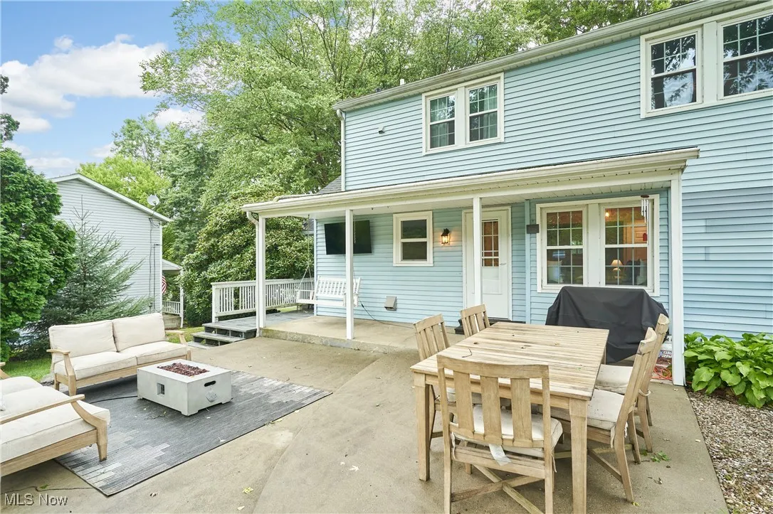 Rear view of house with outdoor dining space, an outdoor living space with a fire pit, and a patio