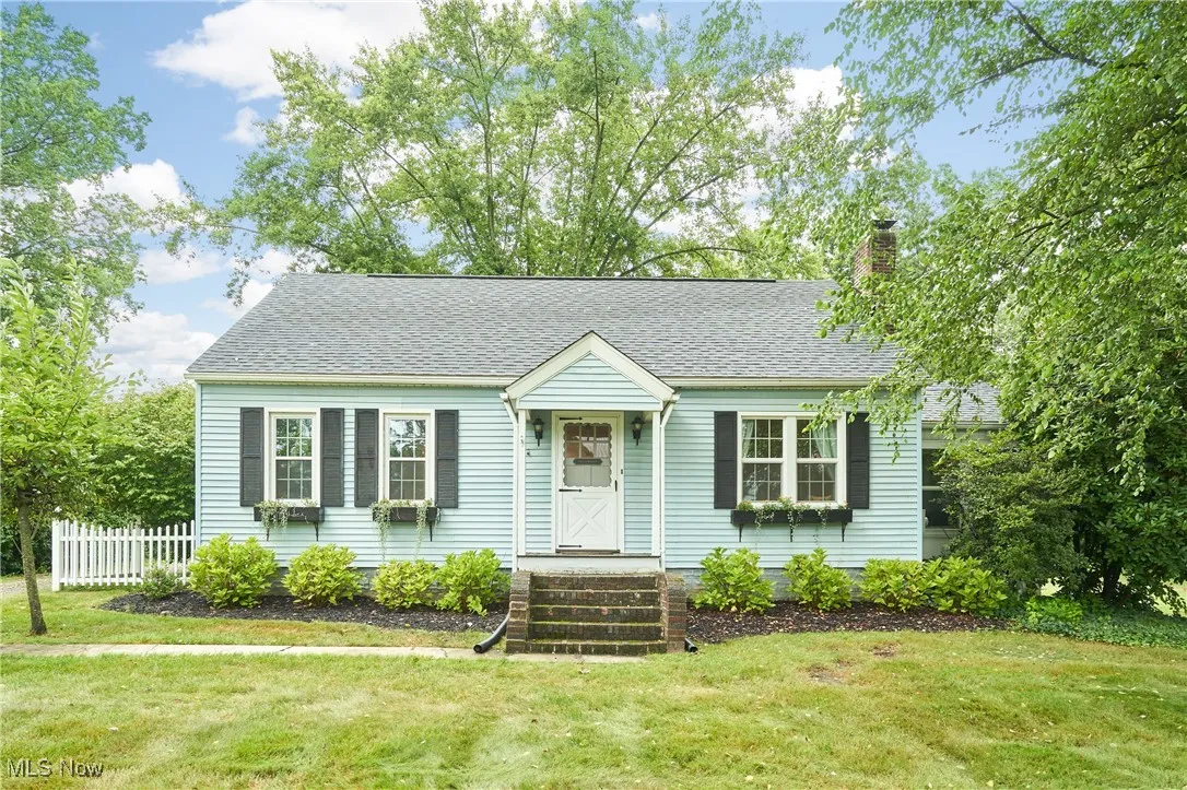 View of front of home featuring a shingled roof and a chimney