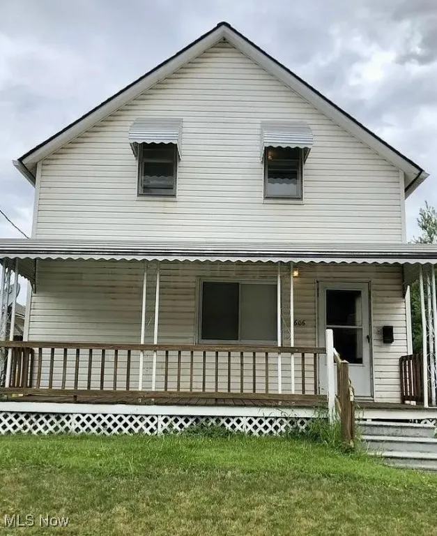 View of front facade featuring covered porch and a front lawn