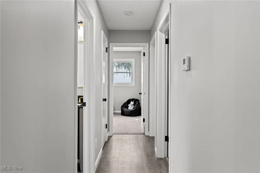 Hall featuring light wood-style flooring and baseboards