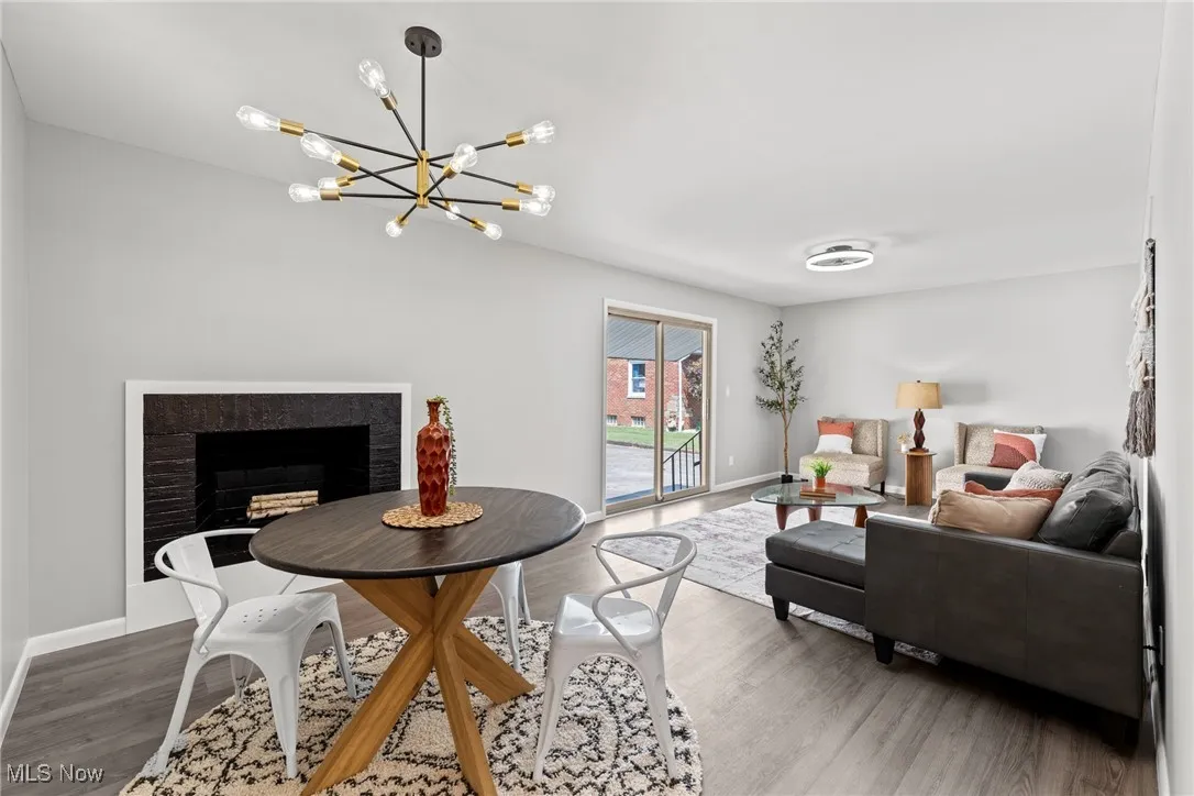 Living room featuring a fireplace, wood finished floors, and a​​‌​​​​‌​​‌‌​‌‌​​​‌‌​‌​‌​‌​​​‌​​ chandelier