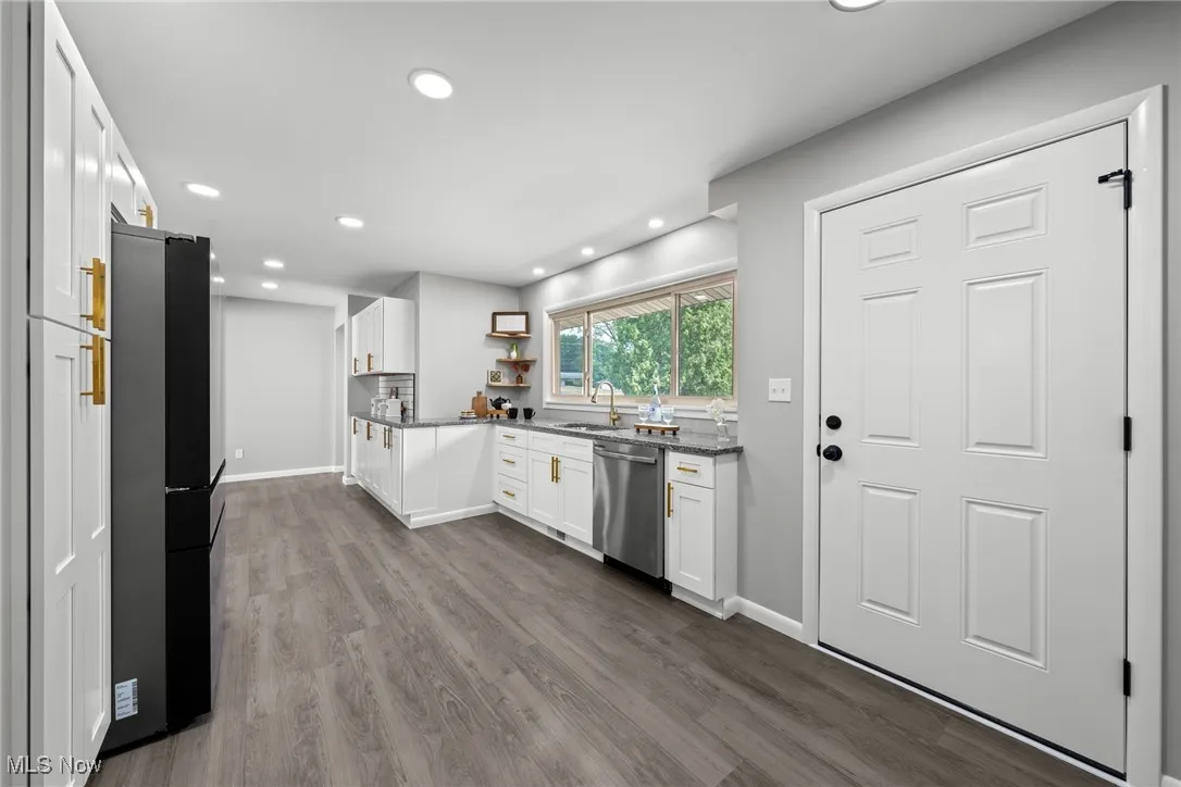 Kitchen with white cabinetry, open shelves, dark stone counters, dark wood-type flooring, and recessed lighting
