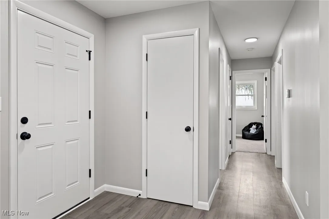 Hallway with baseboards and light wood-style flooring