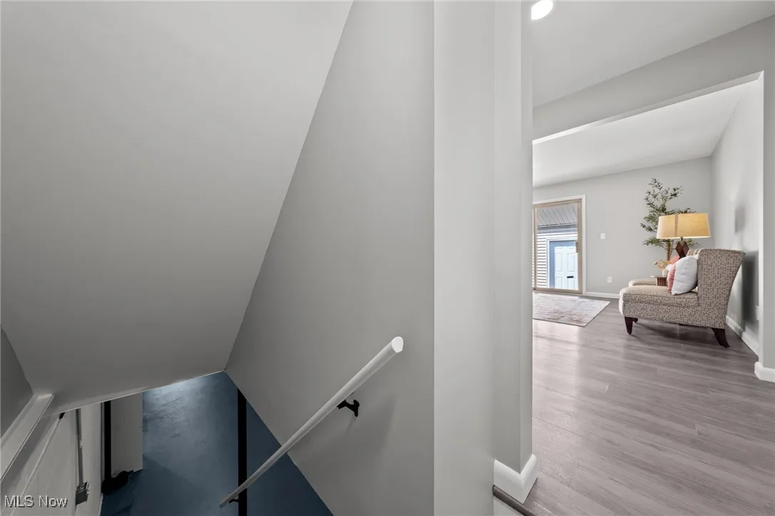 Staircase with wood finished floors and baseboards