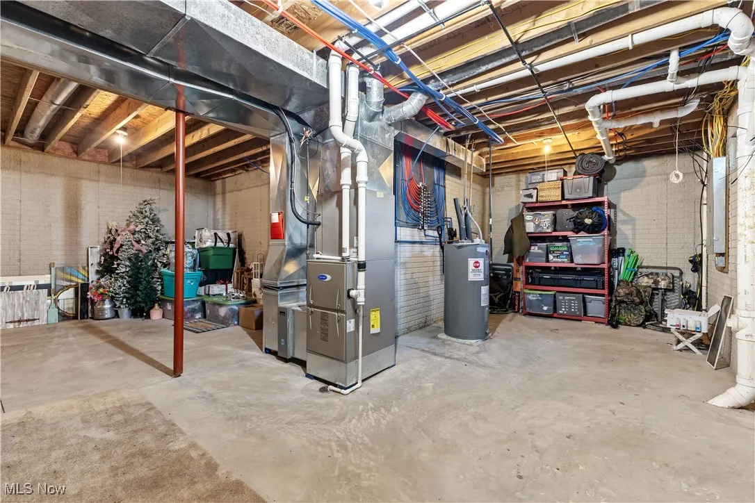 Unfinished basement featuring heating unit and water heater