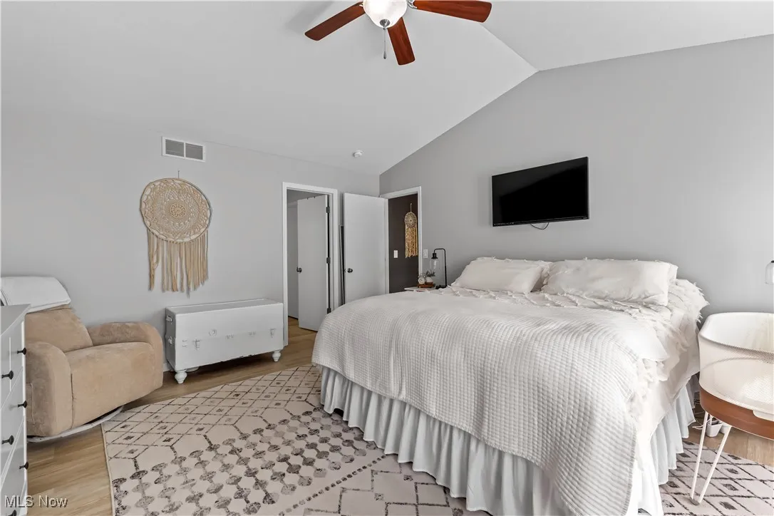 Bedroom featuring lofted ceiling, light wood-style flooring, and a ceiling fan