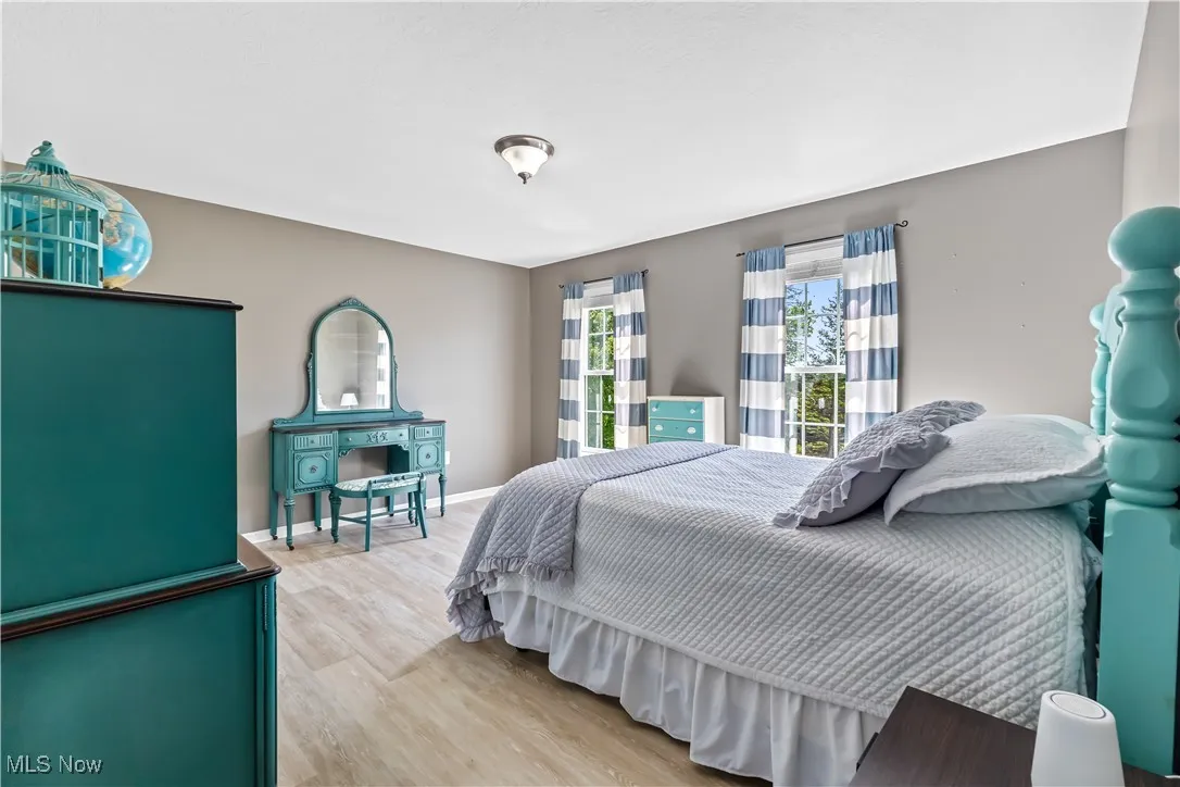 Bedroom featuring wood finished floors and baseboards