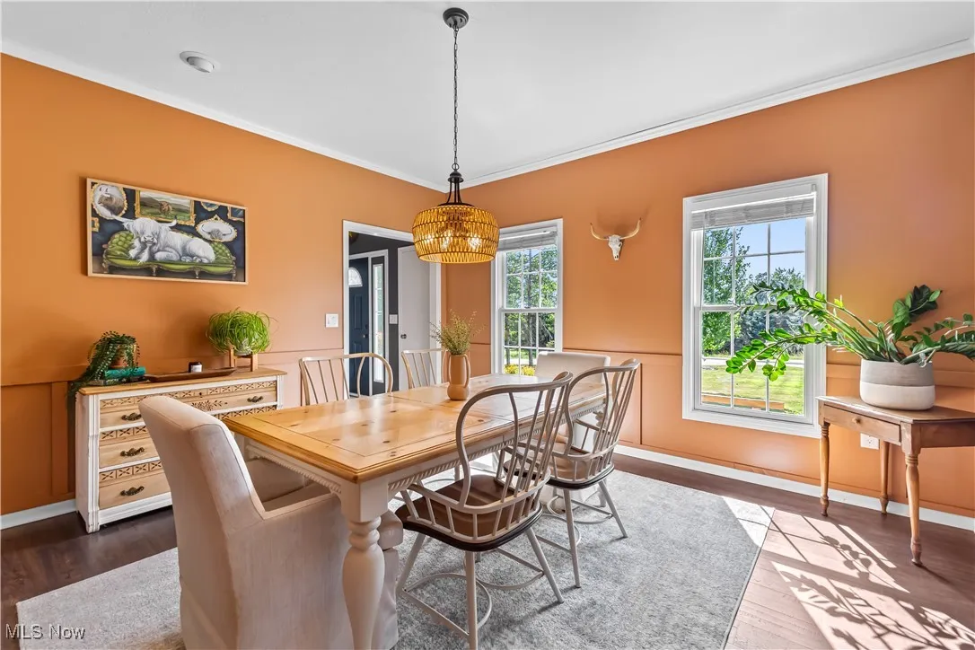 Dining area with crown molding and dark wood finished floors