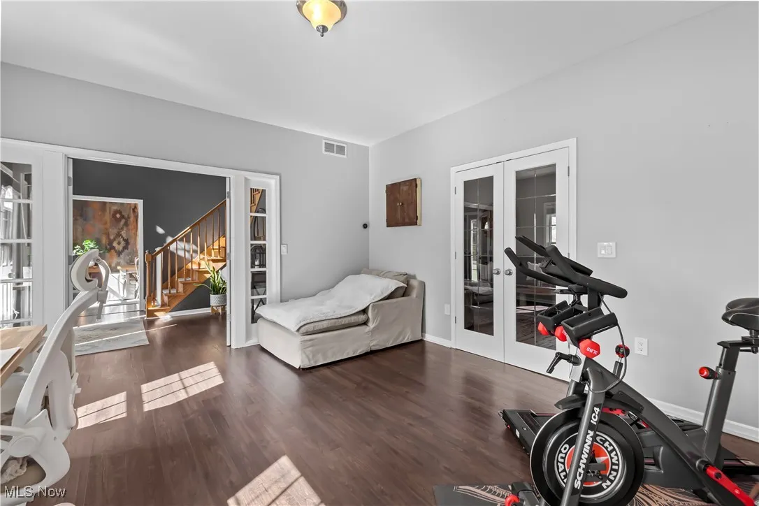 Workout room featuring french doors and dark wood finished floors