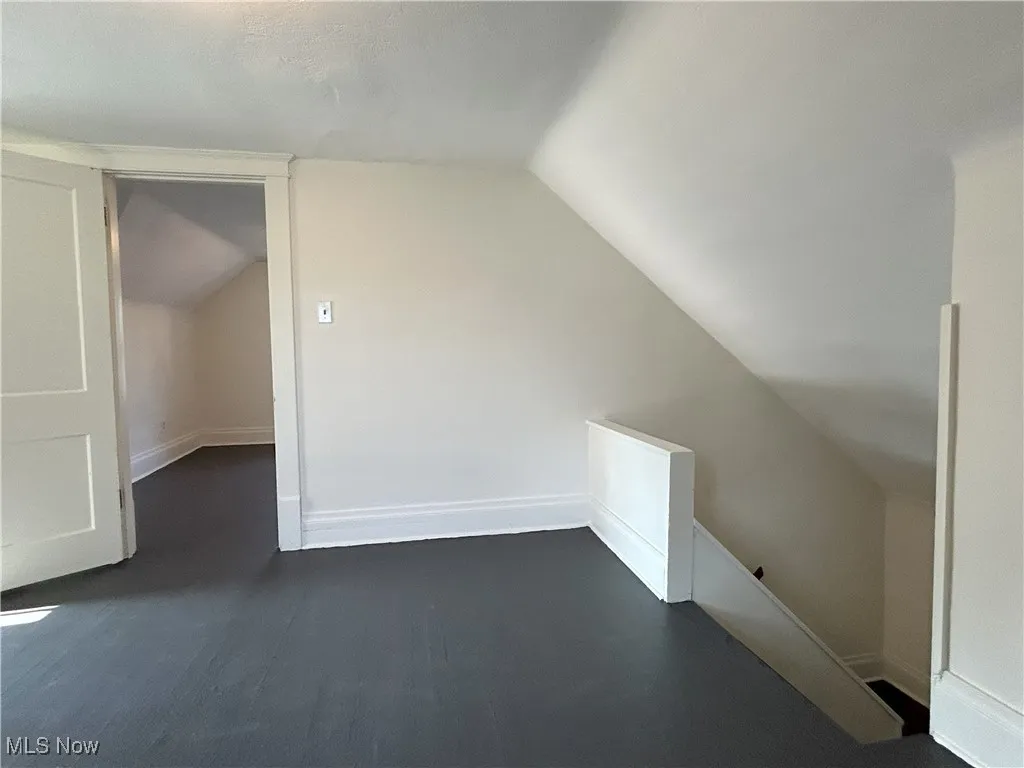 Bonus room featuring lofted ceiling and dark wood finished floors