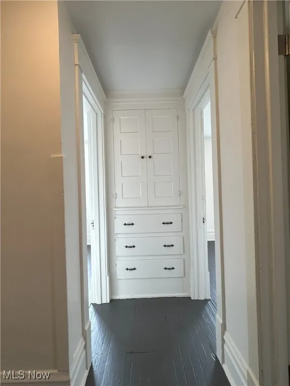 Hall featuring dark wood-style floors and baseboards