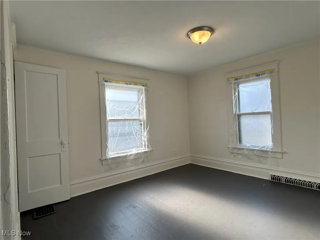 Unfurnished room with healthy amount of natural light and wood finished floors