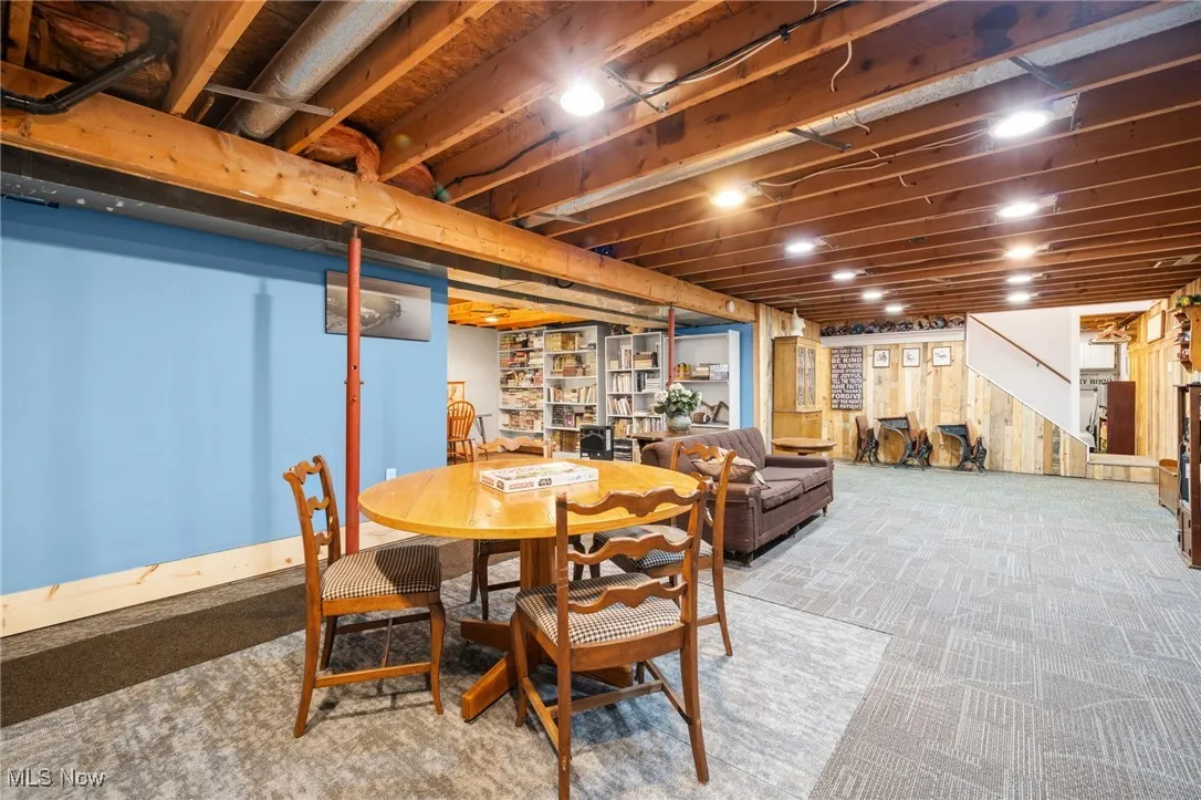 Carpeted dining room featuring wood walls