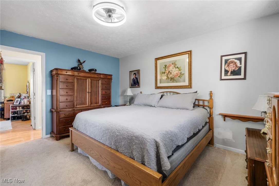 Bedroom featuring light carpet and a textured ceiling