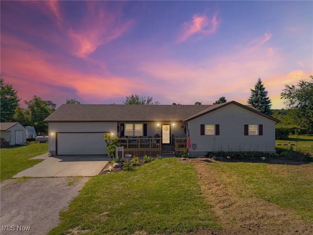 Single story home featuring concrete driveway, an attached garage, and a yard