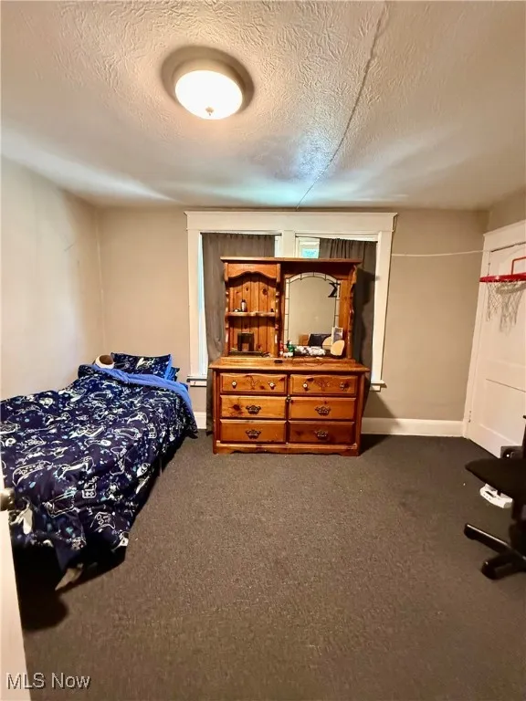 Carpeted bedroom featuring a textured ceiling