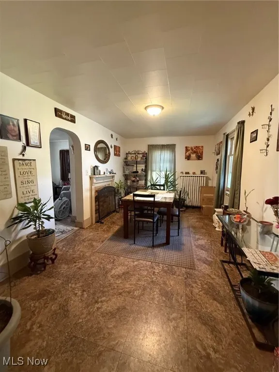 Spacious dining area with arched walkways and a decorative fireplace