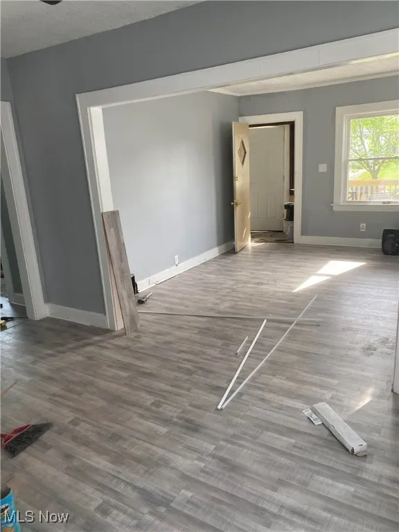 Unfurnished living room with wood finished floors and a textured ceiling