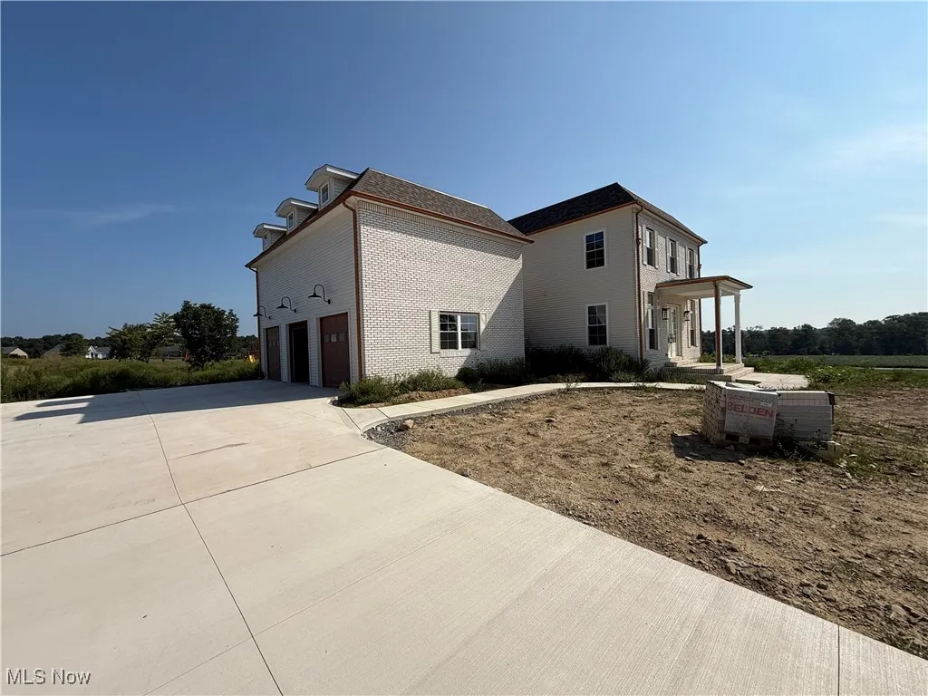 View of home's exterior featuring driveway, brick siding, and an attached garage