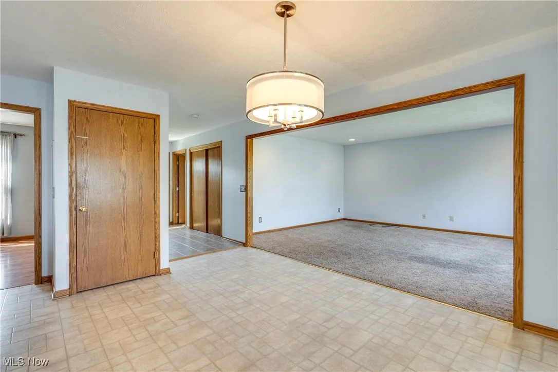 Unfurnished room featuring baseboards and brick patterned floors