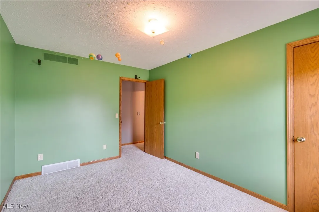 Unfurnished bedroom with carpet and a textured ceiling