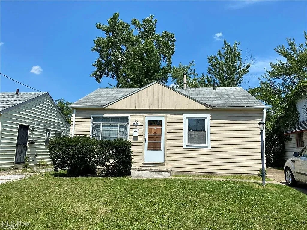 Bungalow-style home featuring a front lawn and roof with shingles