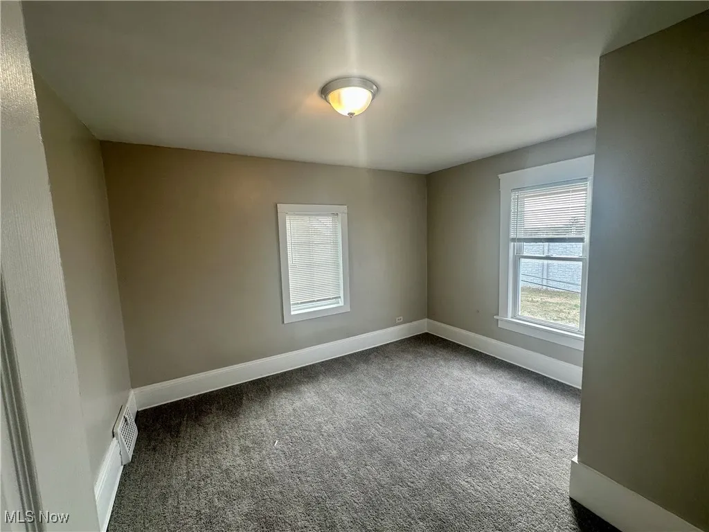 Unfurnished room featuring carpet floors and baseboards