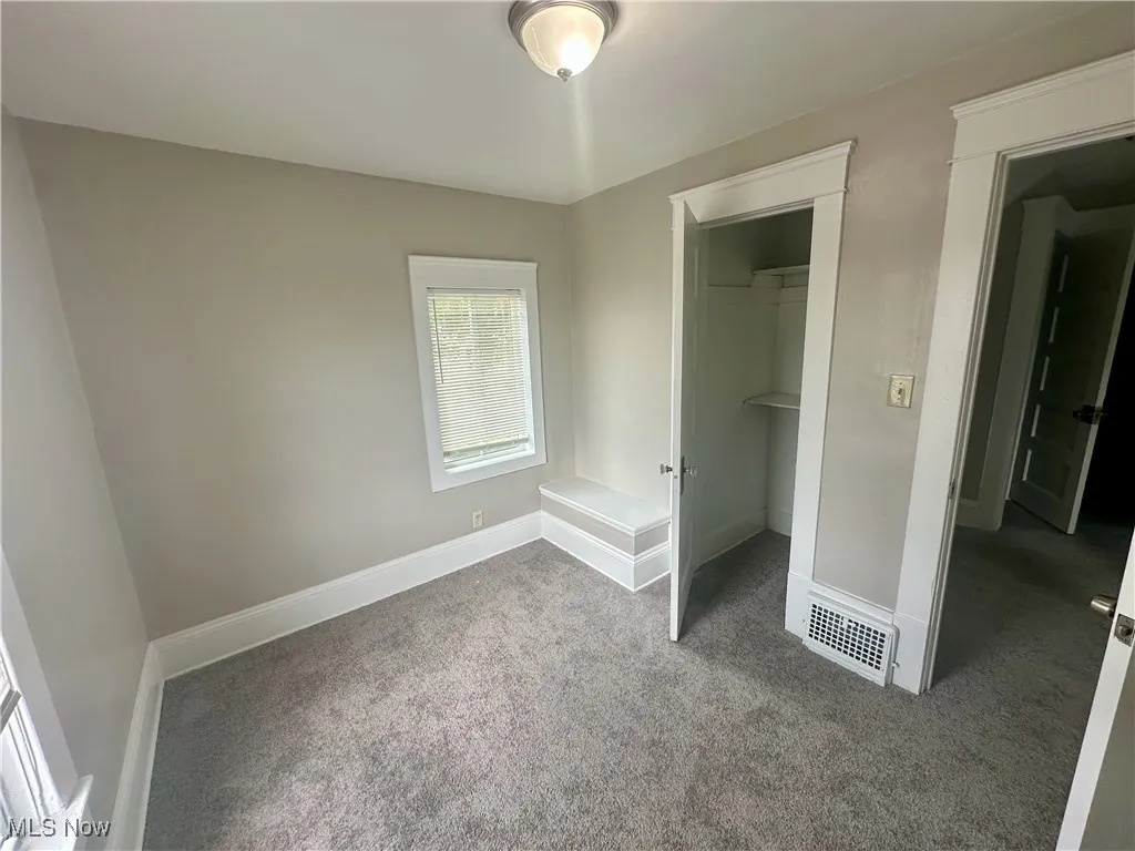 Unfurnished bedroom featuring light colored carpet and a spacious closet