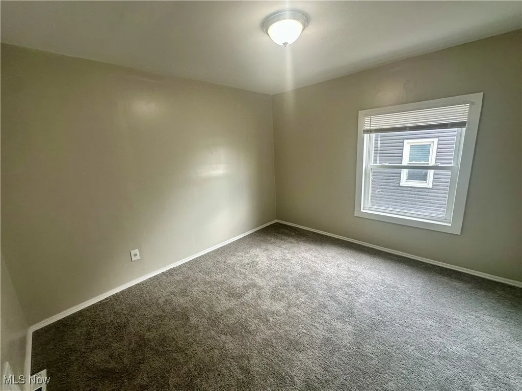 Carpeted empty room with baseboards