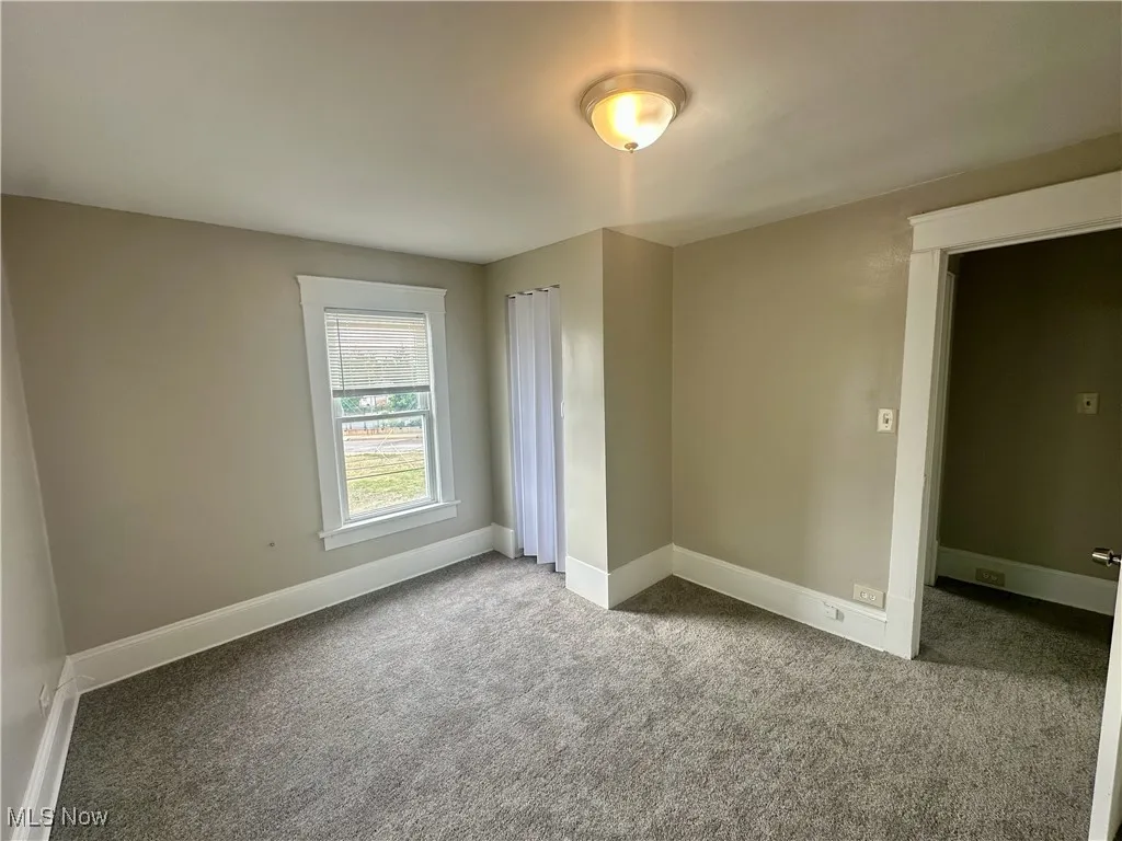 Unfurnished bedroom with carpet flooring and baseboards