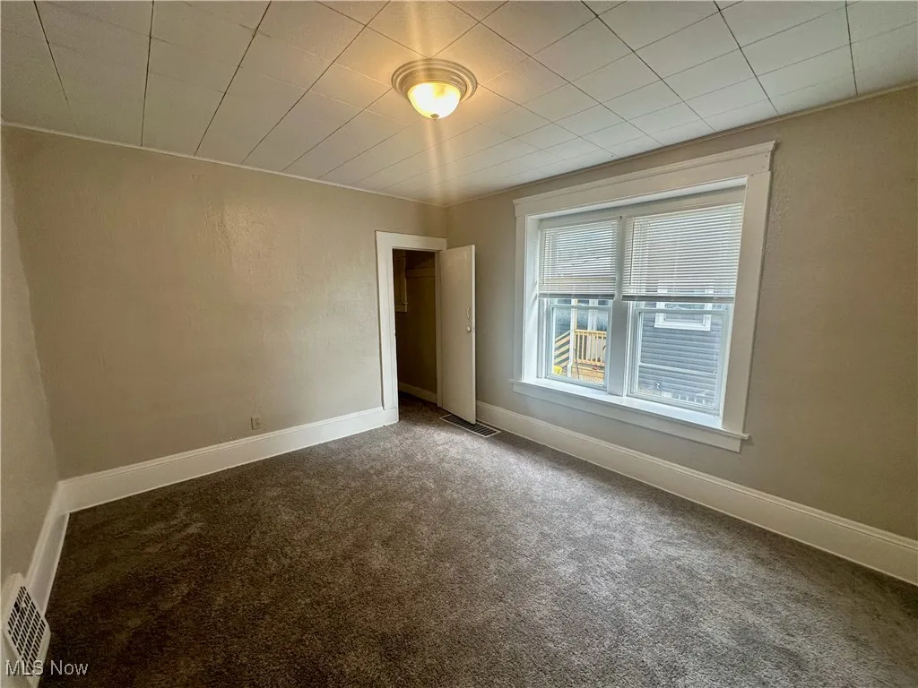 Carpeted spare room featuring baseboards
