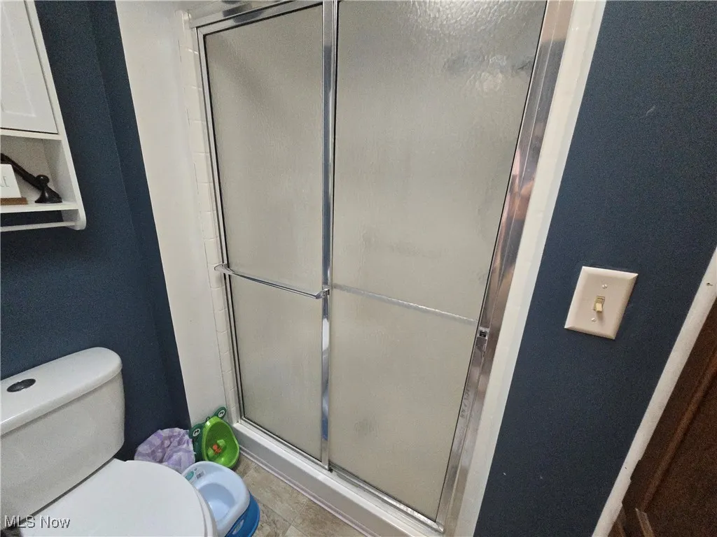 Full bath featuring a stall shower and tile patterned flooring