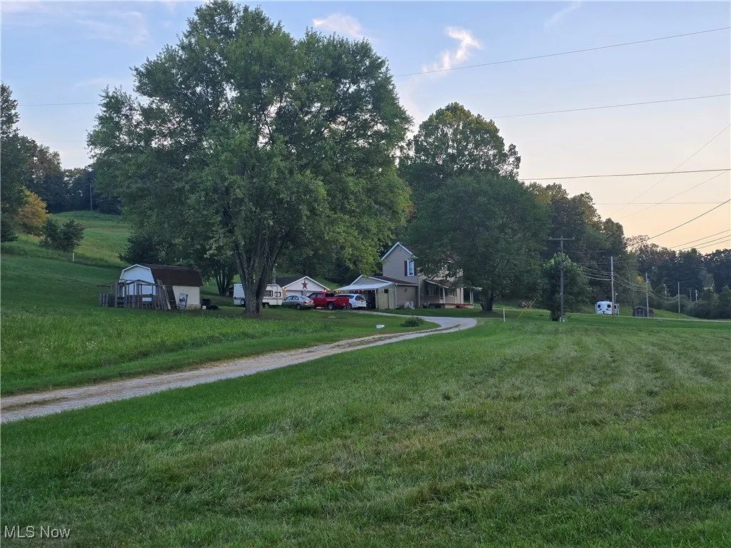View of green lawn with view of wooded area