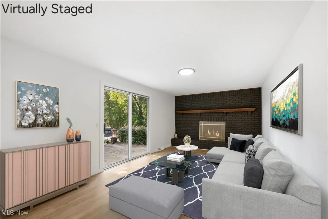 Living area with light wood-style floors and a brick fireplace