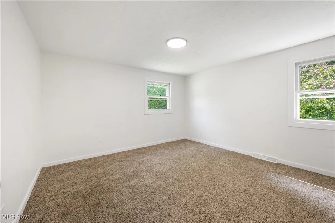 Unfurnished room featuring carpet and baseboards