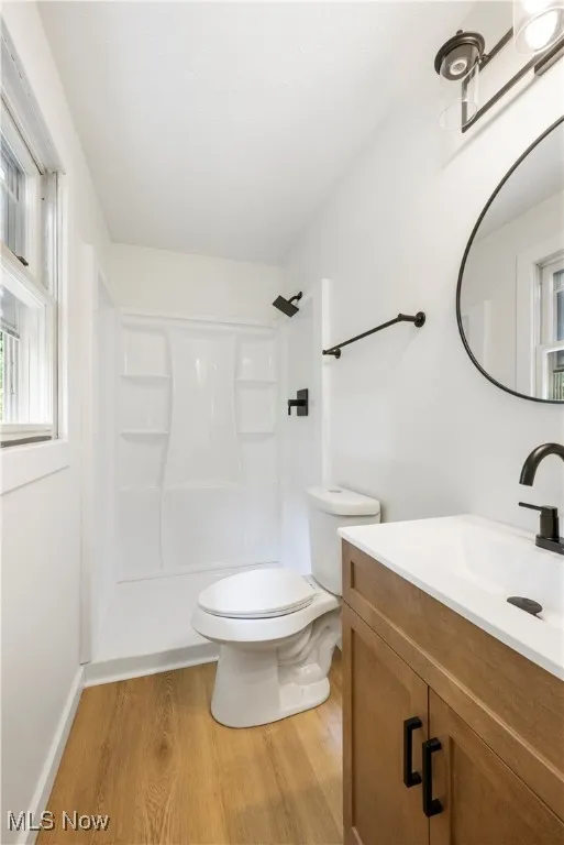 Bathroom featuring vanity, light wood-style flooring, and a stall shower