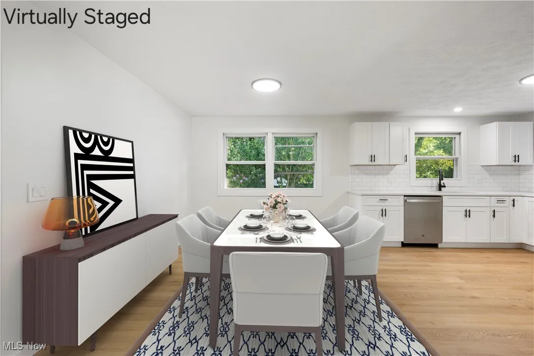 Dining room with light wood-type flooring and recessed lighting