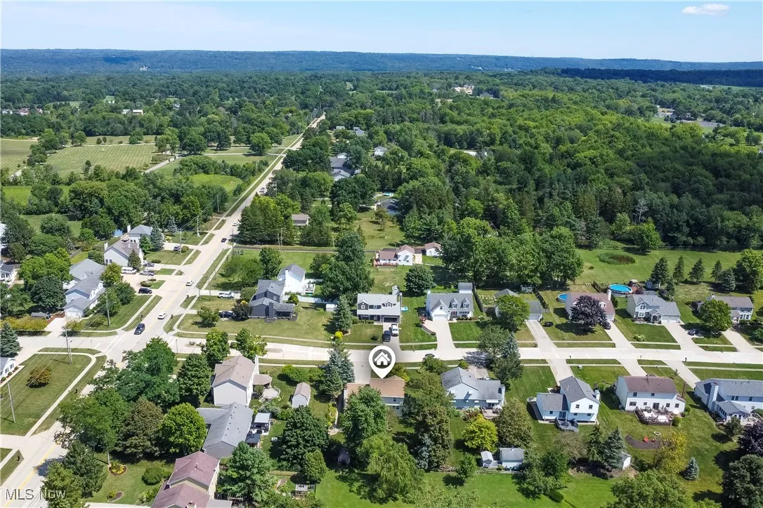 Aerial perspective of suburban area featuring a heavily wooded area