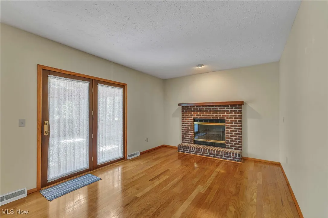 Spacious family room boasting a brick fireplace and doors leading to the 4 season room.