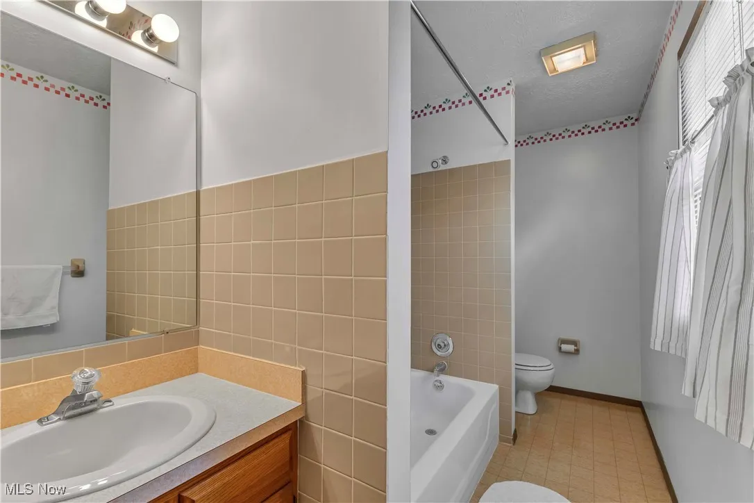 Primary bathroom attached to primary bedroom with tub/shower combo.