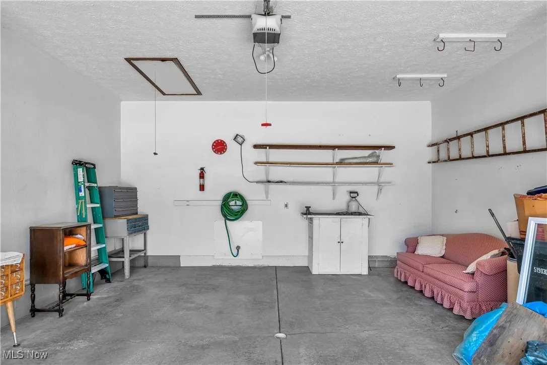 Garage with a garage door opener and overhead storage.