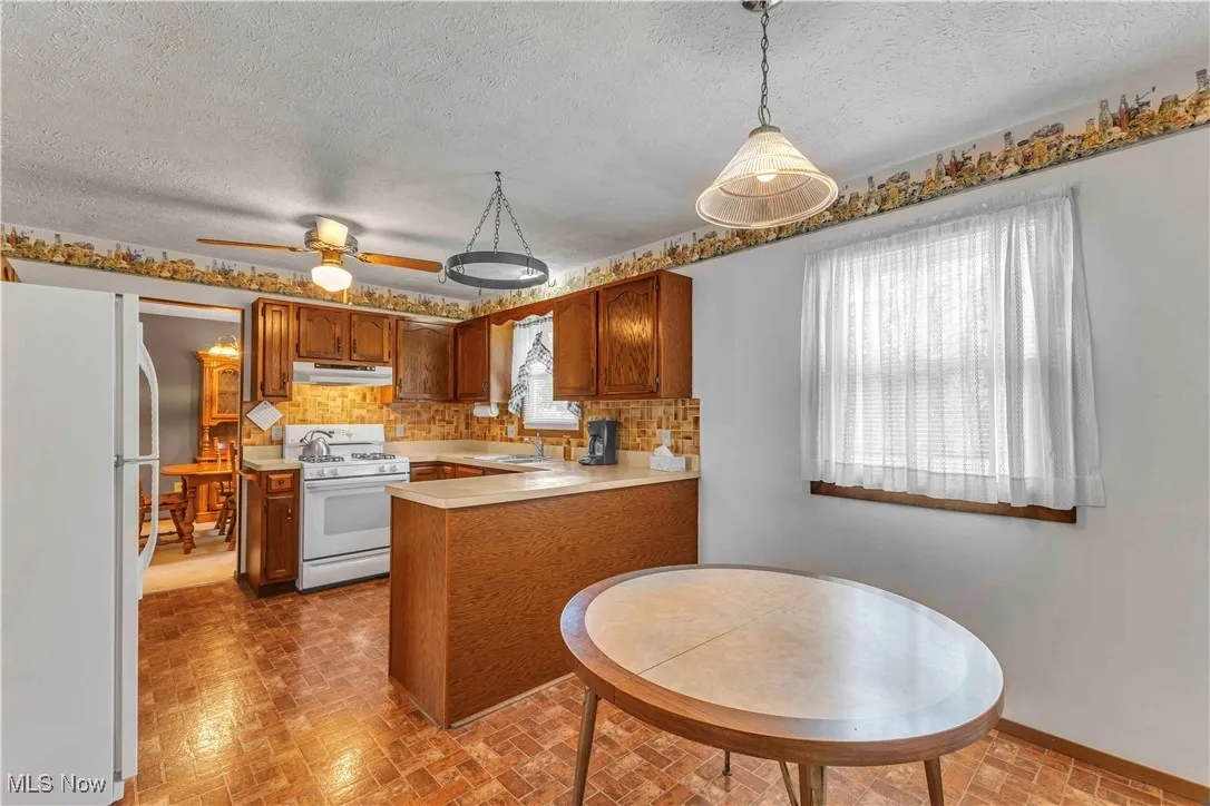 Eat-in kitchen dining area with overhead chandelier and window.
