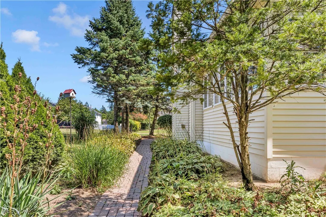 View of a beautifully landscaped walkway from back yard to the garage.