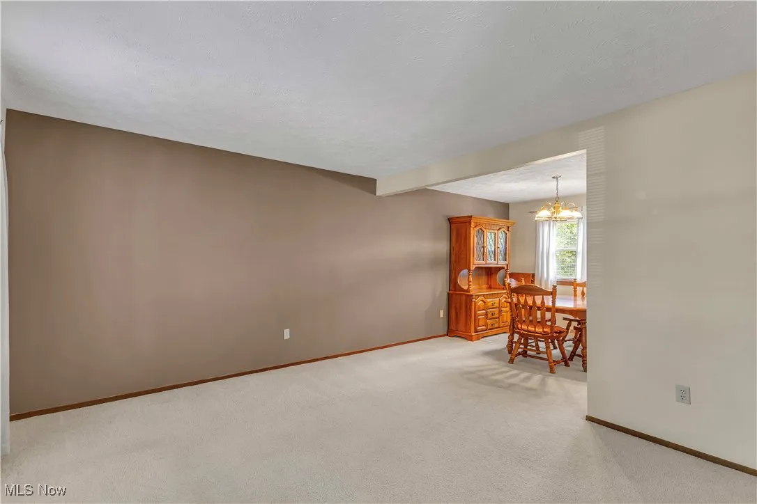 Living room at the front of the home off foyer featuring light carpeting and neutral color walls
