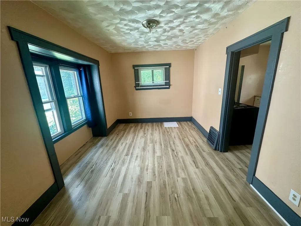Empty room with baseboards and light wood finished floors
