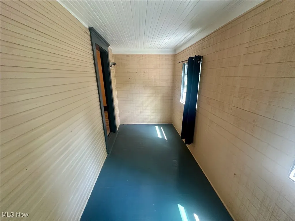 Hall with finished concrete flooring and wooden walls