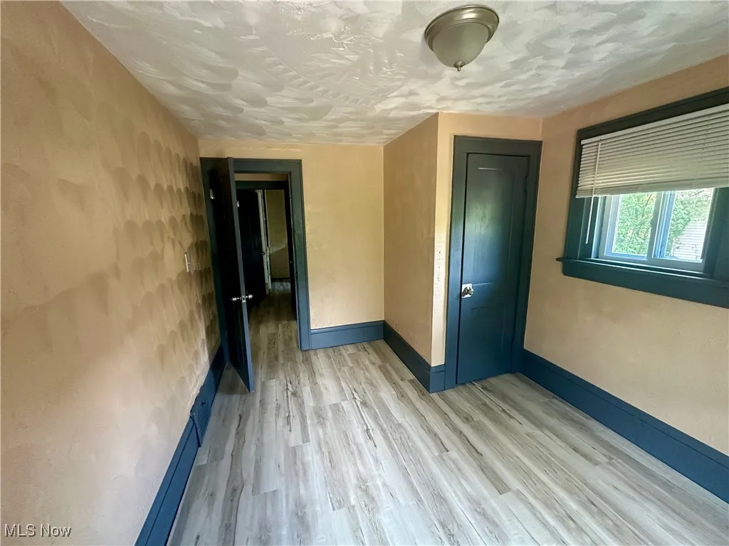Unfurnished room with wood finished floors and a textured ceiling