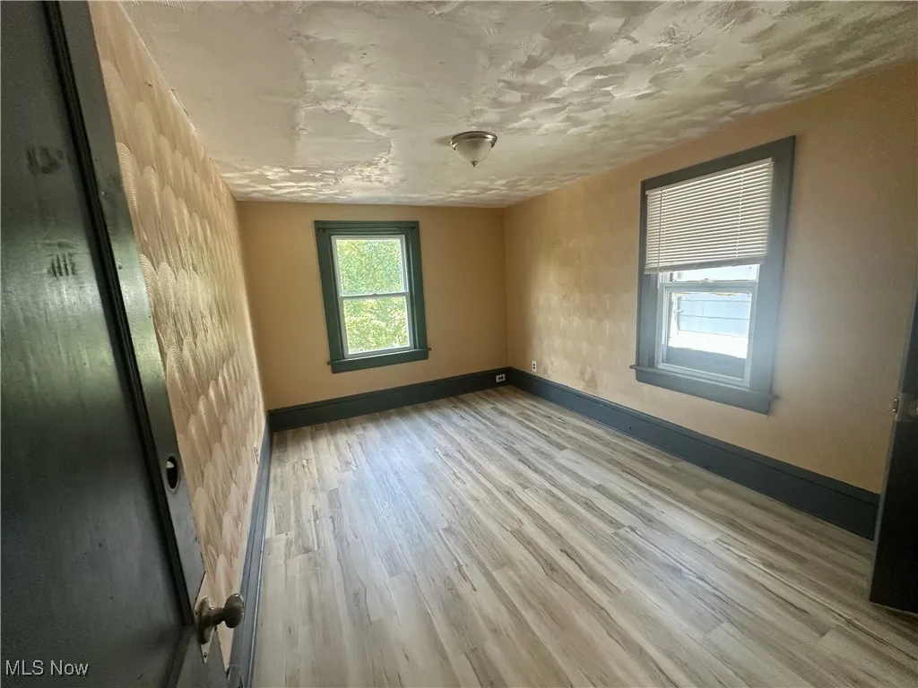 Unfurnished room featuring baseboards and light wood finished floors